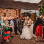 Wedding couple exits to confetti and cheers.