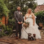 Bride and groom with dachshunds in garden