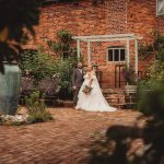 Bride and groom outside brick building