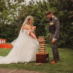 Bride and groom playing outdoor Jenga at wedding