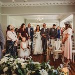 Bride walks down aisle with father at wedding.