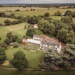 Aerial view of countryside mansion and gardens.