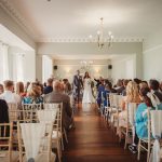 Bride and groom at elegant indoor wedding ceremony.