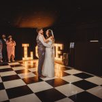 Couple's first dance at wedding with love sign.