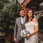 Bride and groom smiling outside on wedding day.