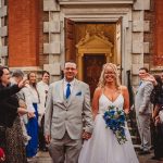 Wedding couple exiting ceremony with guests celebrating.