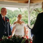 Couple exchanging vows under pavilion.