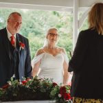 Elderly couple during outdoor wedding ceremony.