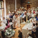 Wedding celebration with guests waving napkins joyfully.