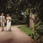 Bride and groom walking in a garden path