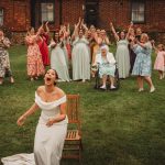 Bride enjoying wedding bouquet toss with bridesmaids cheering