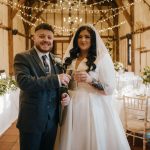 Bride and groom celebrate in rustic venue.