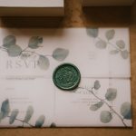 Wedding invitation with green wax seal.