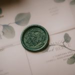 Green wax seal on wedding invitation envelope.