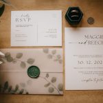 Elegant wedding invitation and RSVP on wooden table.