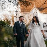 Bride and groom walking outside church