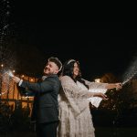 Couple celebrating with champagne at night wedding