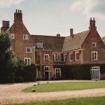 Historic brick manor house with lush gardens.