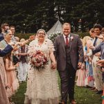 Bride and groom celebrate outdoors with guests.