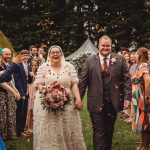 Bride and groom walking through confetti at wedding