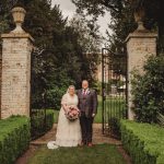 Bride and groom in garden, wedding ceremony setting.