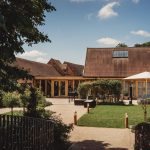 Countryside barn with garden and patio umbrella.