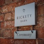 Rickety Barn ceremony sign on brick wall