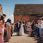 Couple celebrates wedding exit with confetti.