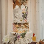 Three-tier wedding cake with floral decorations.