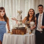 Wedding couple and guest with cake.