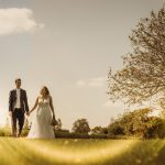 Bride and groom walking in sunny garden