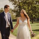 Bride and groom holding hands on sunny day