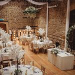 Elegant wedding reception in rustic venue setting.