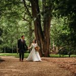 Bride and groom walking in forest