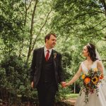 Bride and groom holding hands in forest