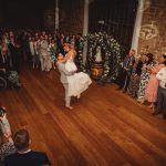 Wedding couple's first dance surrounded by guests.