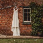 White wedding dress on brick wall