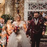 Bride and groom walking through confetti at wedding