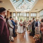 Bride walking down the aisle at indoor wedding.