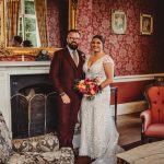 Couple in formal attire at vintage-themed venue.