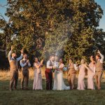 Wedding party celebrating with champagne outdoors.