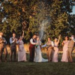 Wedding party celebrating with champagne outdoors.