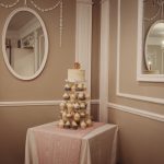 Elegant cupcake tower in a decorative room corner.