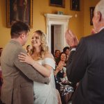 Bride and groom smiling at wedding ceremony.