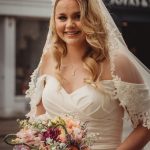 Bride in white dress with colourful bouquet.