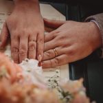 Close-up of couple's hands with wedding rings.