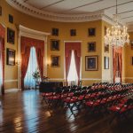 Elegant ceremony room with chairs and chandeliers.