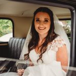 Smiling bride inside vintage wedding car