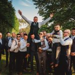 Group of men celebrating outdoors in formal attire.