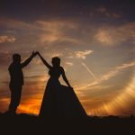 Silhouette of couple dancing at sunset.